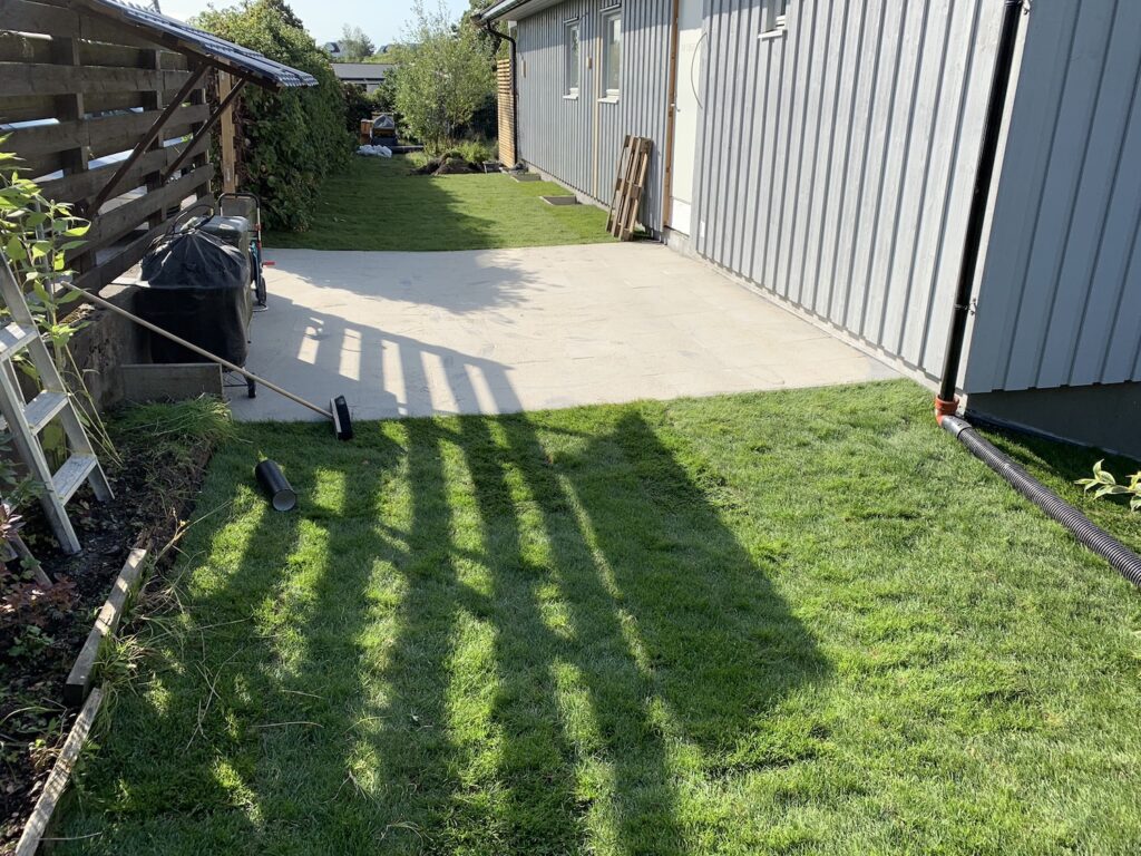 ferdigplen og heller bak et blatt hus.